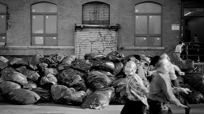 A large heap of rubbish bags in an alley by Viviana Peretti.