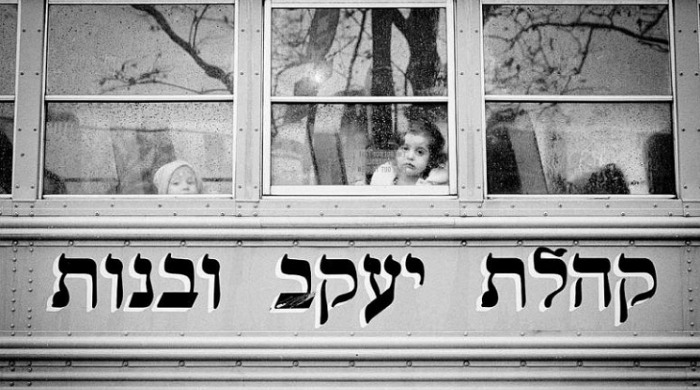 Two young girls looking out of a bus window by Viviana Peretti.