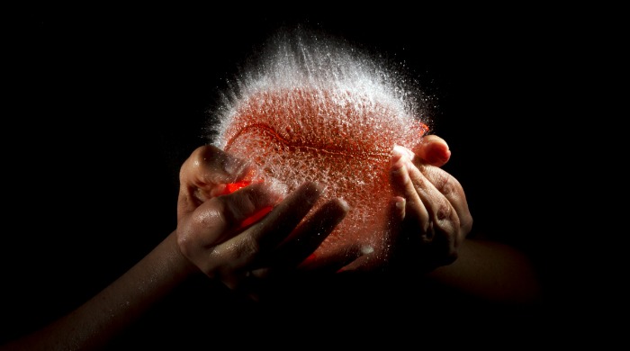 A red water balloon bursting by Edward Horsford.