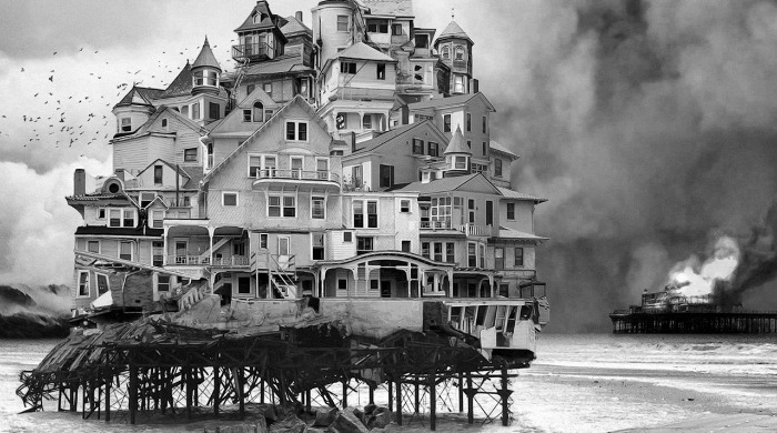 A large house on stilts on the beach in black and white by Jim Kazanjian.