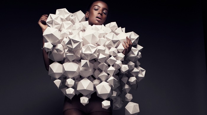 A model wearing a series of 3D, geometric paper shapes by Bea Szenfeld.
