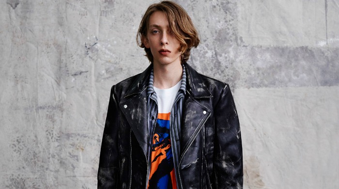 A male model wearing a McQ Alexander McQueen leather jacket.