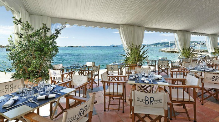 An outdoor dining area by the sea at the Hotel Belles Rives.