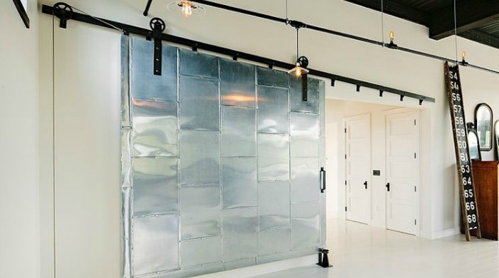 A large, metallic sliding door in an industrial Portland loft.