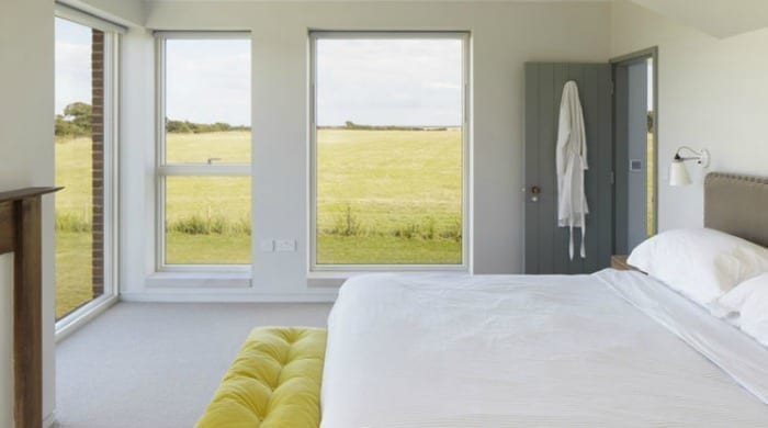 A bedroom in Lucy Marston's Suffolk farmhouse with views of the surrounding fields.