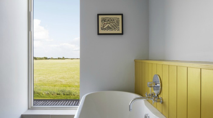 The bathroom in Lucy Marston's Suffolk farmhouse with yellow panelled wood detail.