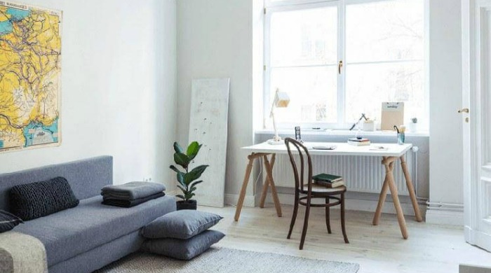 The lounge of a Berlin apartment with a potted plant.