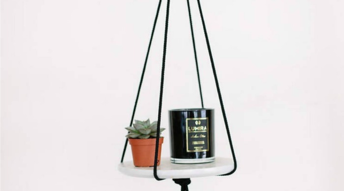 A DIY marble hanger with a small plant and candle on it.