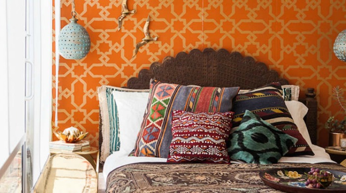 A bed with colourful patterned pillows and sheets from the modern bohemia trend.