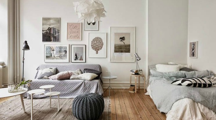 A studio apartment with framed prints on the wall from Apartment Therapy.