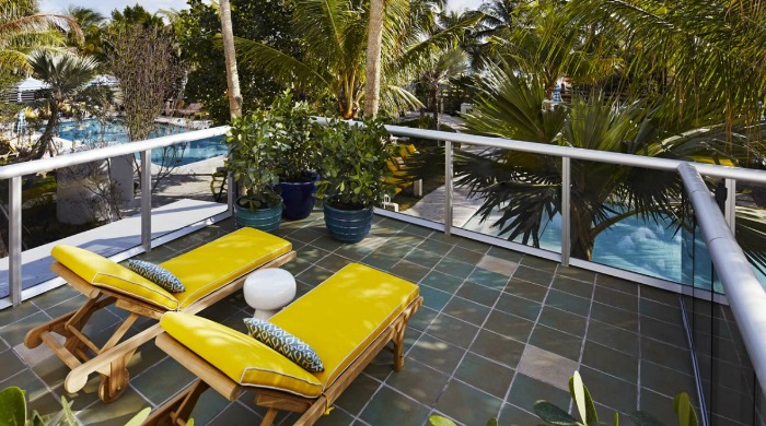 A balcony with two yellow sun loungers in the Thompson Miami Beach hotel.