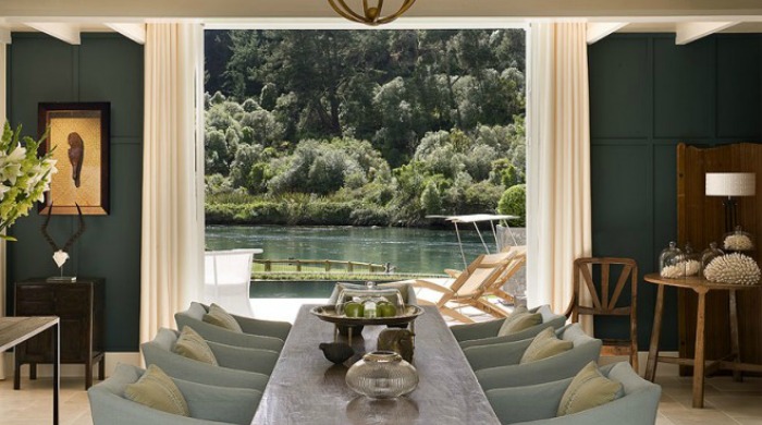 An indoor dining area with views of the lake in Huka Lodge, New Zealand.